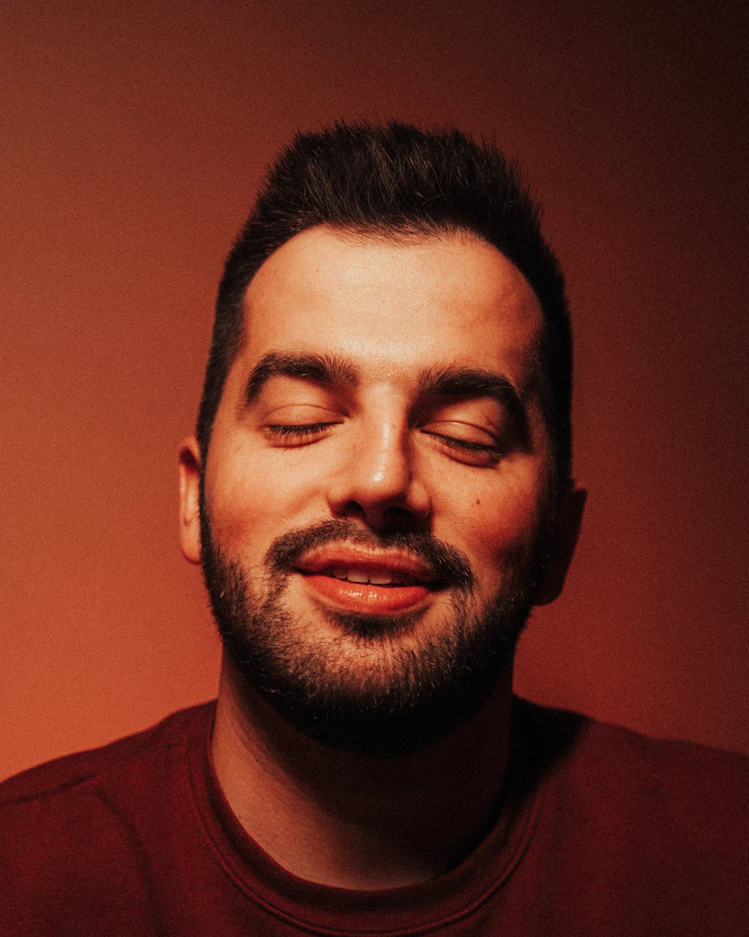 Homem sorrindo de olhos fechados, relaxado